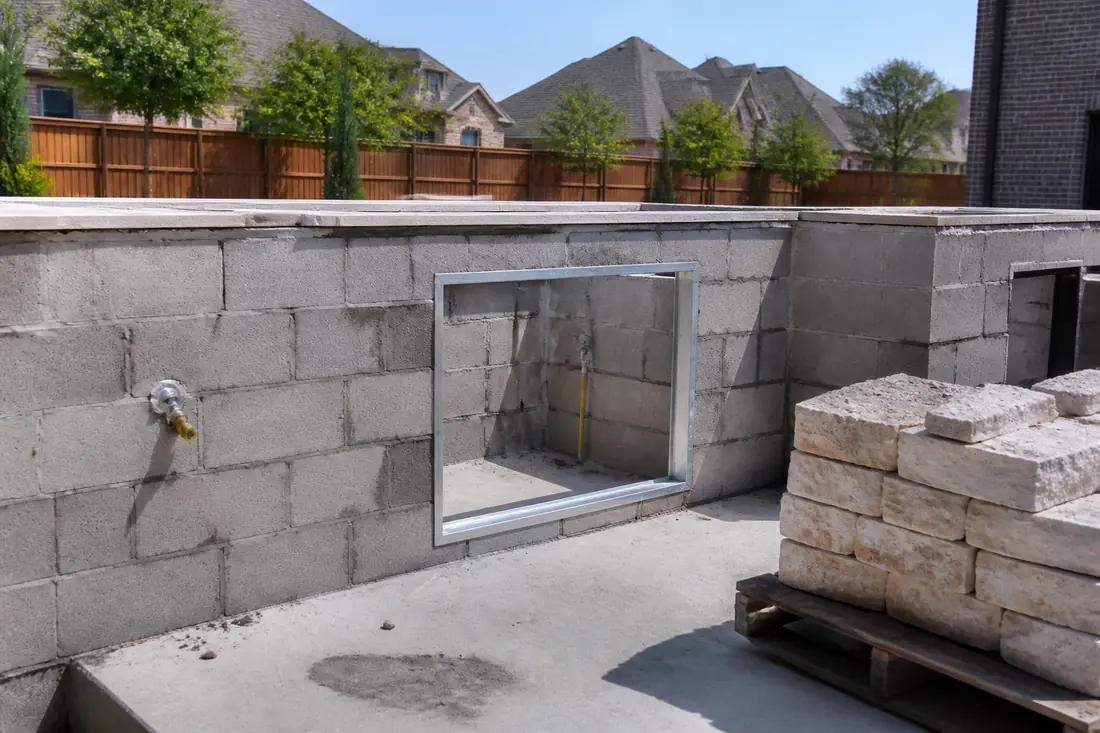 An outdoor kitchen block core under construction with an appliance opening framed