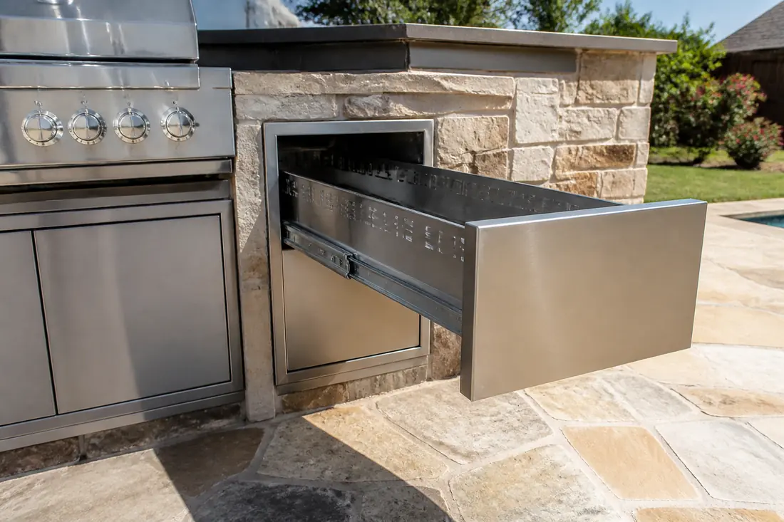 A drawer unit pulled fully open beside a built-in grill