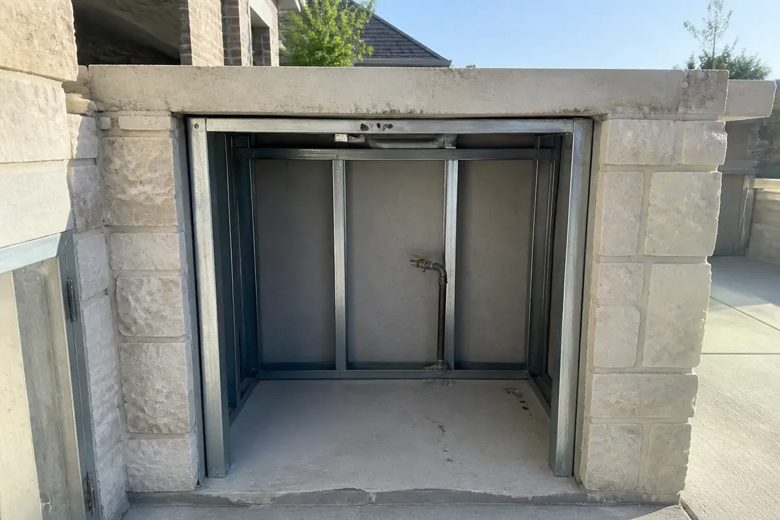 The framed cavity of an outdoor kitchen island before the grill is set in