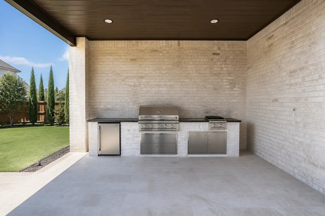 An outdoor kitchen with a roof and walls on three sides